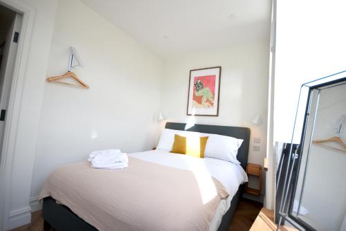 a bedroom with a bed with white sheets and yellow pillows at CITYeSCAPE - 2BR apt 2 ensuite Sofa Bed NQ in Manchester