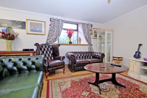 a living room with leather chairs and a table at Grand Mansion 9 Beds Sleeps 17 Parking - Groups in Aberdeen