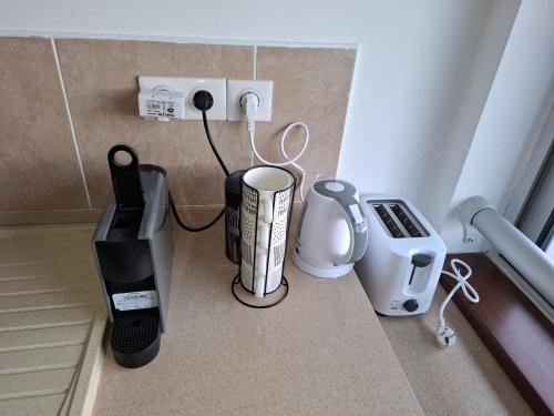 a kitchen counter with a coffee maker and a blender at Appartement NANA-B21-La terrasse in Cayenne