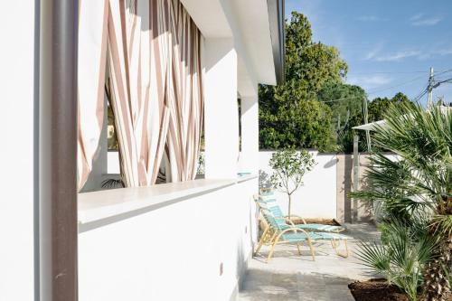 a white house with a patio with a surfboard at Villa Torre Ulisse Locazione Turistica Affitti Brevi in Carini