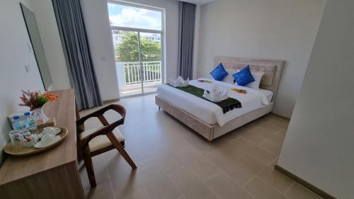 シアヌークビルにあるDa San Hotelのベッドとテーブルと窓のある寝室