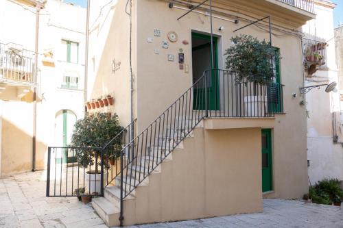 a building with stairs and a green door at Lues Rooms in Ragusa