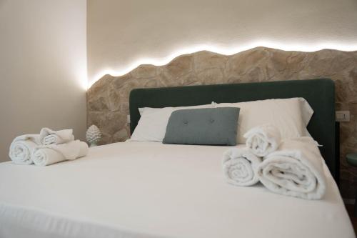 a bedroom with a white bed with towels on it at Lues Rooms in Ragusa