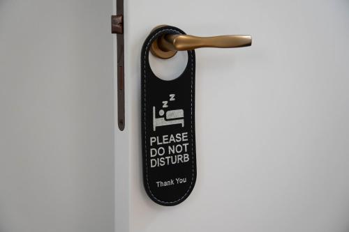 a door handle with a sticker that says please do not disturb at Lues Rooms in Ragusa