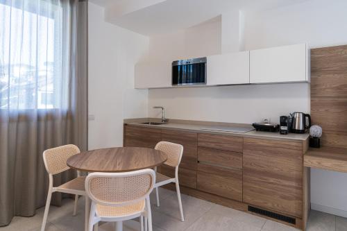 a kitchen with a table and chairs in a room at Appartamento Fiordaliso - Cascina Da Rosa in Capiago Intimiano