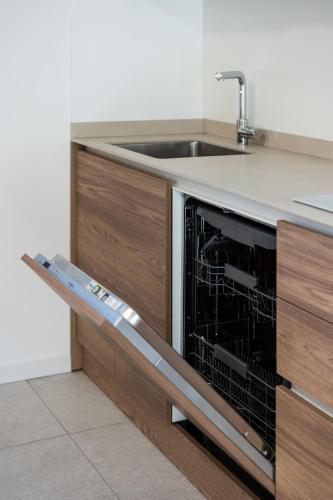 a kitchen with a sink and a dishwasher at Appartamento Fiordaliso - Cascina Da Rosa in Capiago Intimiano