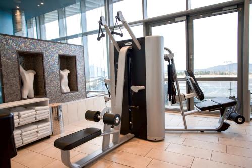 a gym with cardio equipment in a room with windows at Clarion Hotel Bergen Airport in Bergen