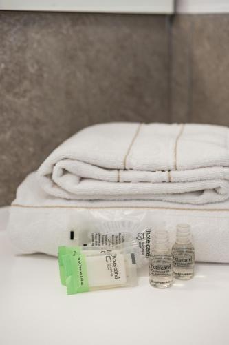 a pile of towels and toothbrushes on a counter with towels at Appartamento Fiordaliso - Cascina Da Rosa in Capiago Intimiano