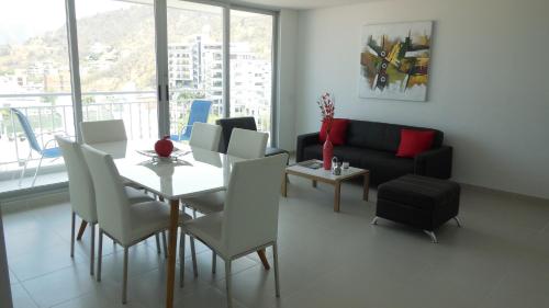 sala de estar con mesa, sillas y sofá en Apartamento Rodadero VICO, en Santa Marta