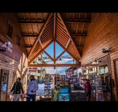 a group of people walking around a store in a building at Chalet Joue du loup 6-7 pers in Le Dévoluy
