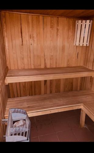 a wooden bench in a sauna with a basket at Chalet Joue du loup 6-7 pers in Le Dévoluy
