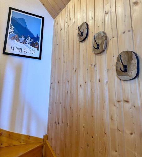 a wall with hats on it with a picture at Chalet Joue du loup 6-7 pers in Le Dévoluy