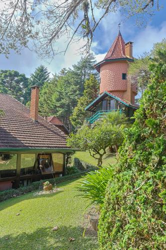 a house with a tower on top of a yard at Pousada Cantos e Contos in Monte Verde