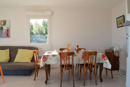 une salle à manger avec une table, des chaises et un canapé dans l'établissement SP020-A06 Appt 3 pièces 6 couchages SAINT PIERRE LA MER, à Saint Pierre La Mer