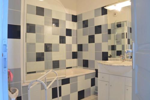 une salle de bain avec une baignoire, un lavabo et un miroir dans l'établissement SP020-A06 Appt 3 pièces 6 couchages SAINT PIERRE LA MER, à Saint Pierre La Mer