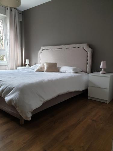 une chambre avec un grand lit blanc avec deux lampes dans l'établissement Appartement 115 m2 Garage Tram Lille St Maur, à Lille