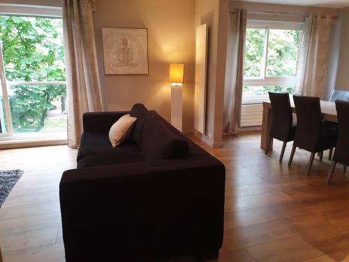 a living room with a couch and a dining table at Appartement 115 m2 Garage Tram Lille St Maur in Lille