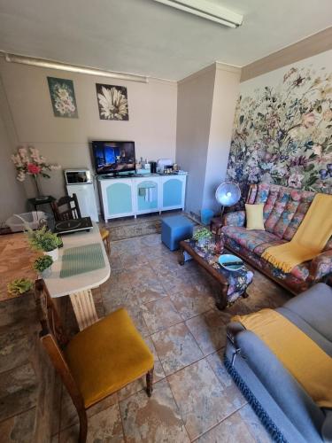 a living room with a couch and a table at Durbanville CPT Pet Friendly, Self-Catering in Oakdale