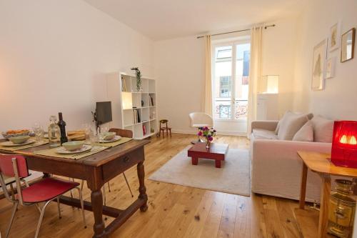 un salon avec une table et un canapé dans l'établissement Geranimus Picasso Heart of Paris, à Paris