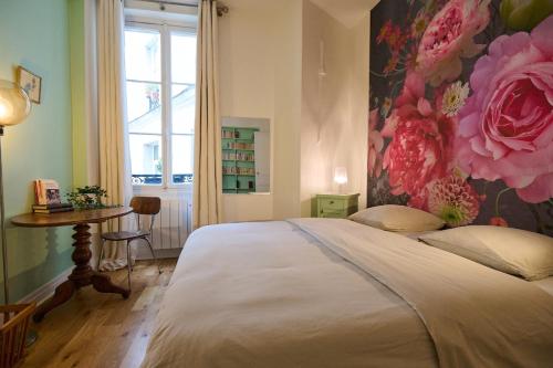 - une chambre avec un grand lit et un mur fleuri dans l'établissement Geranimus Picasso Heart of Paris, à Paris