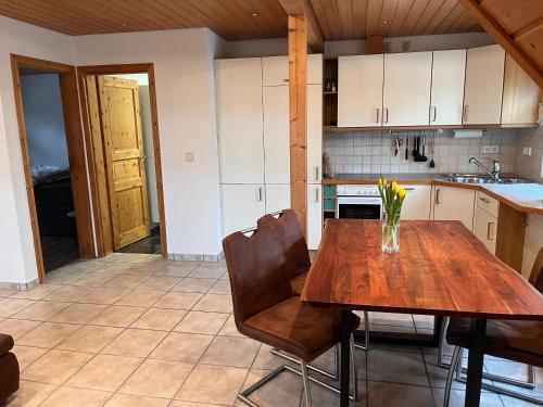 a kitchen with a wooden table and chairs at Dachstub in Brackenheim