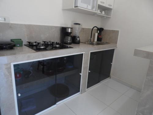 a small kitchen with a stove and a sink at Apartamento Inteligente - Japaratinga in Japaratinga