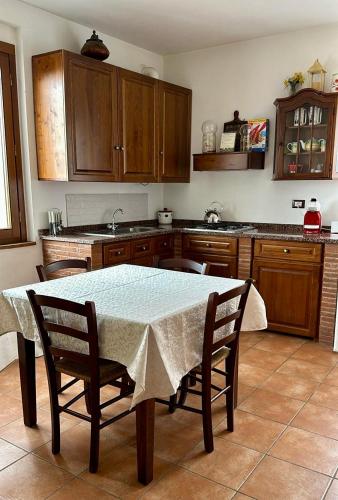 a kitchen with a table and chairs and a table and cabinets at Madonna Del Poggio CAV in Scarlino