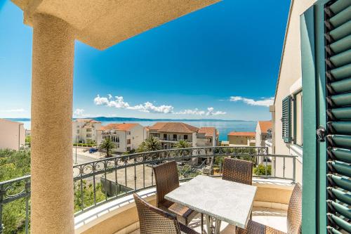 a balcony with a table and chairs and a view of the ocean at Villa Tucepi Beach in Tučepi