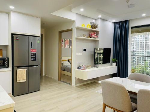 a kitchen and living room with a refrigerator and a table at Suzon-Luxurious Apartment at Lumiere Boulevard VGP in Gò Công