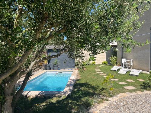 - une piscine dans une cour avec un arbre dans l'établissement Le l'islois- Park&Piscine, à LʼIsle-sur-la-Sorgue