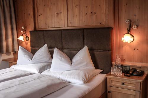 a bedroom with a bed with white pillows on it at Metzgerwirt in Hippach