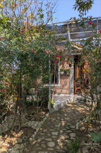 a garden with a house with red roses at Homestay Mộc Nhi in Hue