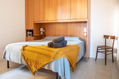a bedroom with a bed with a yellow blanket at Under the Lemon Tree in La Caletta