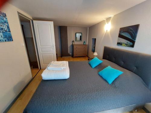 une chambre avec un grand lit avec des oreillers bleus dans l'établissement Horizon des Corbières, à Saint-André-de-Roquelongue