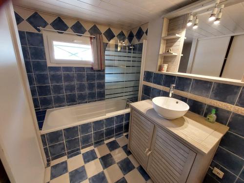 La salle de bains est pourvue de carrelage bleu, d'un lavabo et d'une baignoire. dans l'établissement Horizon des Corbières, à Saint-André-de-Roquelongue