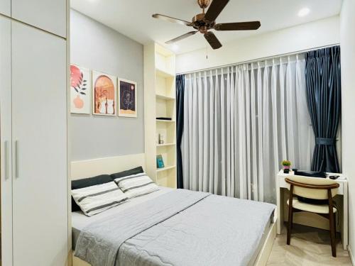 a bedroom with a bed and a desk at Suzon-Luxurious Apartment at Lumiere Boulevard VGP in Gò Công