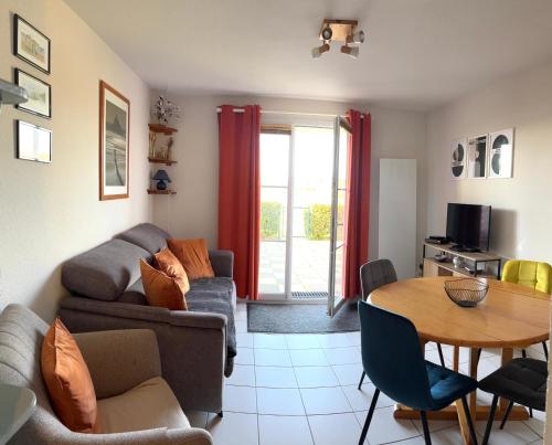 un salon avec un canapé et une table dans l'établissement Maison en bord de mer, à Dives-sur-Mer