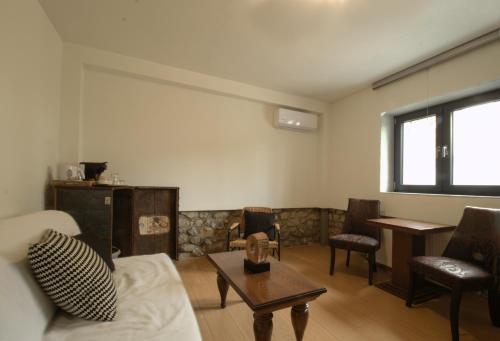 a living room with a couch and chairs and a table at 1951 Suites in Kalabaka