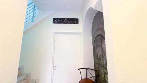 a white room with a door and a sign on the wall at Do Campanili by Ca-Sa Check in Chioggia