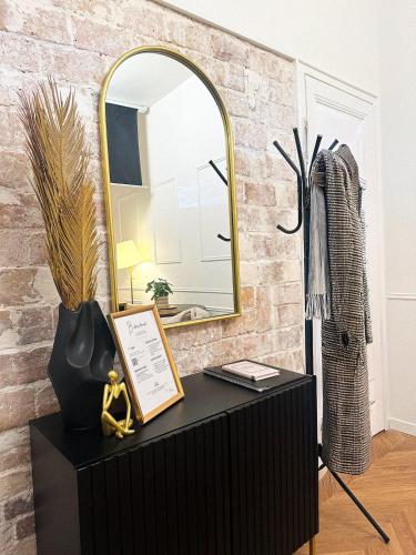 un miroir sur un mur de briques à côté d'une table noire dans l'établissement Balnéo & cinéma suspendu - Paris 14ème, à Paris