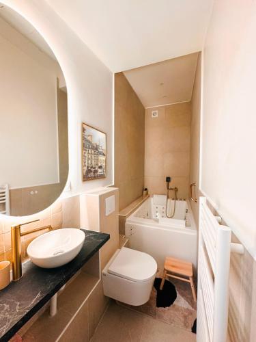 une salle de bain avec un lavabo, des toilettes et une baignoire dans l'établissement Balnéo & cinéma suspendu - Paris 14ème, à Paris
