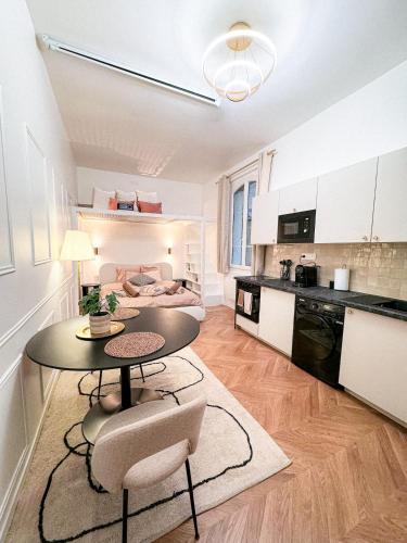 une cuisine et un salon avec une table et des chaises dans l'établissement Balnéo & cinéma suspendu - Paris 14ème, à Paris