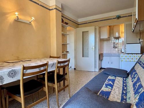 une cuisine avec une table et des chaises dans une pièce dans l'établissement Appartement 2 pièces 4 couchages ARGELES SUR MER AR420-047, à Argelès-sur-Mer