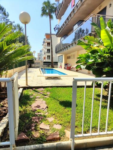 a white fence in front of a swimming pool at Enjoy the beach in Bellreguart