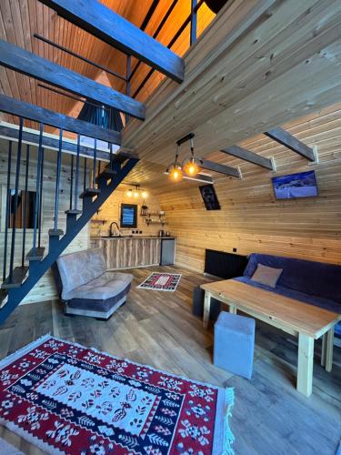 a living room with a table and a couch at Kazbegi Harmony Cottages in Kazbegi