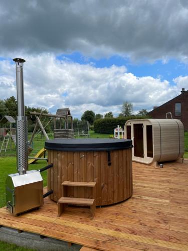 a wooden deck with a playground with a play structure at Le Sabot in Nassogne