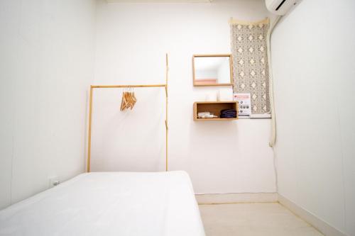 a white room with a bed and a refrigerator at YAB-GuestHouse, FemaleOnly, ForeignOnly in Seoul