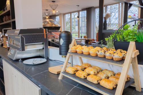 a bakery with shelves of pastries on a counter at Holiday Inn - the niu, Blade Solingen by IHG in Solingen