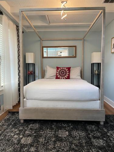 a bedroom with a canopy bed with a red pillow at Peace & Plenty Inn Bed and Breakfast Downtown St Augustine-Adults Only in Saint Augustine