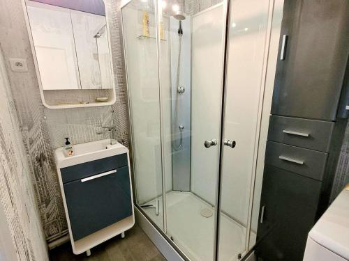 une salle de bain avec une douche en verre et un lavabo dans l'établissement Charmant T2 avec Balcon à Deux Pas de la Digue, Plein Ouest - Cuisine Équipée, Séjour Lumineux - FR-1-675-24, à Wimereux